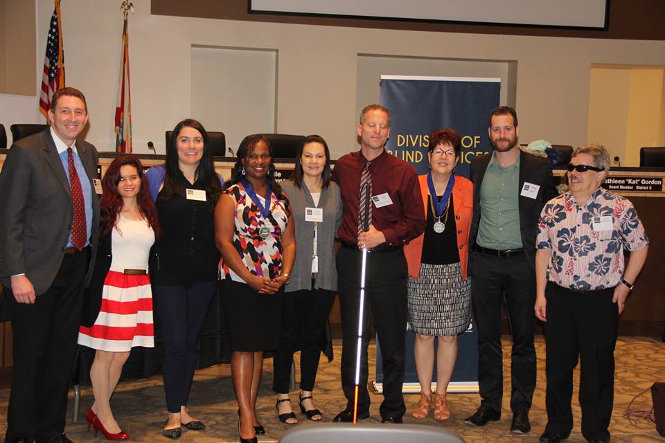Lighthouse Central Florida staff accepts Successful 75 Award from DBS administrators Jeff Whitehead and Mireya Hernandez
